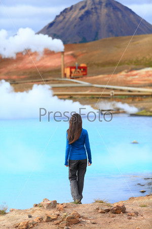 Iceland hot spring geothermal energy power plant in Namafjall in Lake Myvatn area. Woman tourist enjoying Icelandic nature landscape on Route 1 Ring Road.
