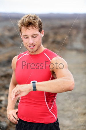 Running man looking at heart rate monitor GPS watch