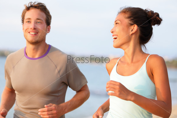 Jogging fitness young mixed race couple running happy smiling and laughing enjoying sports outdoors. Exercising multicultural people - young caucasian man and pretty asian model