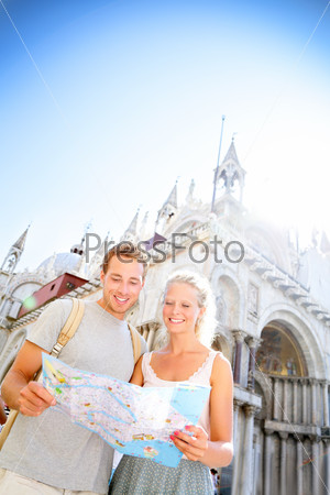 Travel Couple Reading Map On In Venice, Italy On Piazza San Marco In Front Of Saint Mark\'S Basilica. Happy Young Couple On Travel Vacation In Europe. Happy Woman And Man In Love Traveling Together.