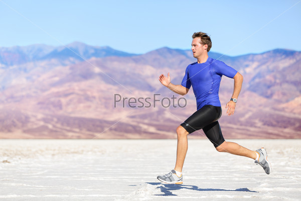 Man running outdoor sprinting for success. Male fitness runner sport athlete in sprint at great speed in beautiful landscape in desert.