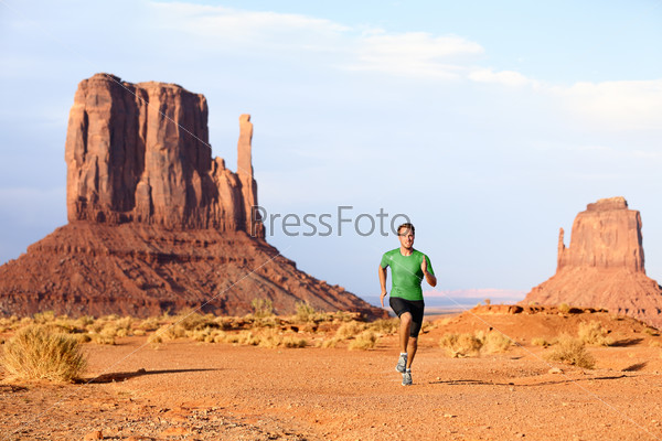Runner. Running man sprinting in Monument Valley. Athlete runner cross country trail running outdoors in amazing nature landscape. Fit male sports model in fast sprint at speed, Arizona Utah, USA.