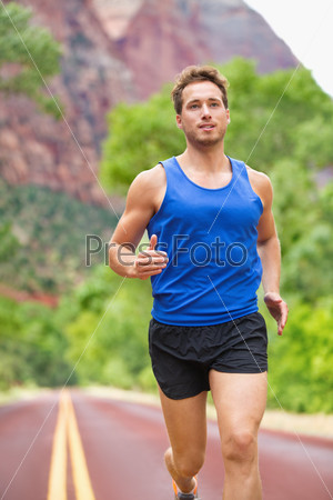 Athlete runner running on road. Fitness man jogging in workout wellness concept. Fit muscular male fitness model training for marathon run.