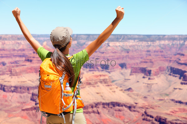 Success winner person happy hiker in Grand Canyon. Woman cheering with arms raised up in winning gesture enjoying the beautiful landscape. Hiking girl wearing backpack during summer in, Arizona, USA.
