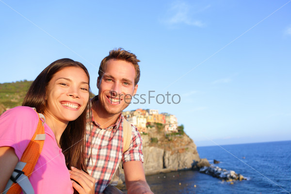 Selfie - couple in love in Cinque Terre, Italy. Romantic couple taking self portrait photo on holidays travel. Young man and woman backpackers on vacation in Manarola, Cinque Terre, Liguria, Italy