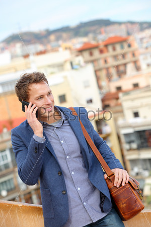 Man on smart phone - young business man talking on smartphone. Casual urban professional businessman using mobile cell phone smiling happy walking. Handsome man wearing suit jacket in Barcelona, Spain