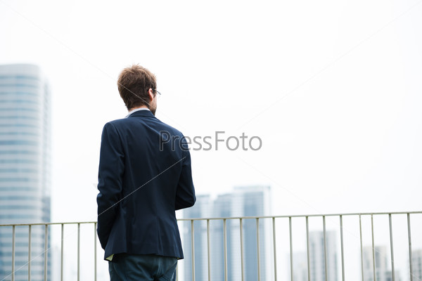 Rear view of businessman standing on balcony