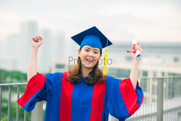 Portrait of a cheerful graduate in gown and graduation hat