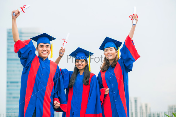 Portrait of three former students rejoicing their graduation