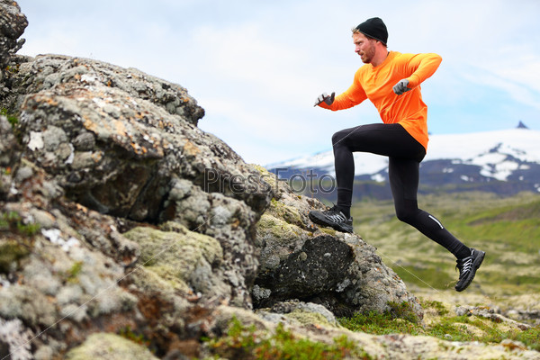 Sport running man in cross country trail run. Fit male runner exercise training and jumping outdoors in beautiful mountain nature landscape with Snaefellsjokull, Snaefellsnes, Iceland.