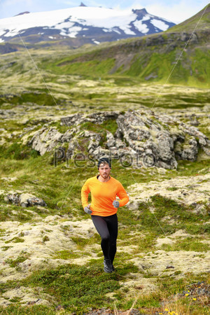 Trail running man in cross country run. Fit male runner training jogging outdoors in beautiful mountain nature landscape with Snaefellsjokull, Snaefellsnes, Iceland.