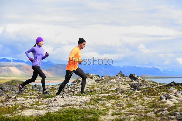 Running people trail runners in cross country run. Woman and man runners training jogging outdoors in beautiful mountain nature landscape on Snaefellsnes, Iceland.