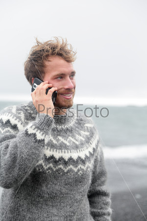 Smartphone man talking on phone on beach, Iceland