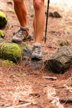 Hiker - close up of male hiking shoes and boots. Man on hike in forest.