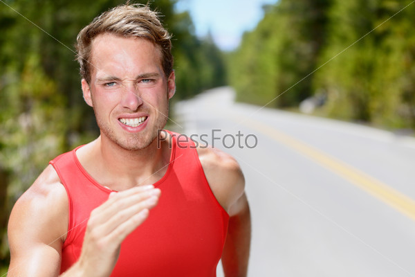 Man runner running on road training, jogging and exercising for trail run marathon endurance race. Fitness healthy lifestyle concept with male athlete trail runner.