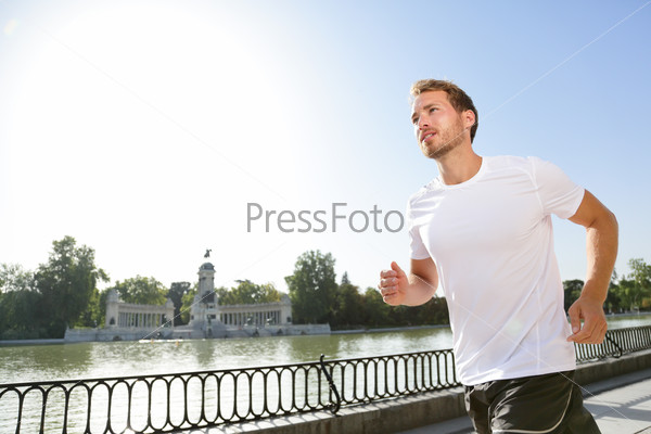 Jogging man running in city park El Retiro Madrid. Male runner exercising and training on run living healthy active lifestyle in Buen Retiro Park, Parque el Retiro in Madrid, Spain, Europe.