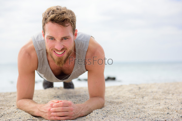Crossfit training fitness man doing plank core exercise working out his midsection muscles. Fit athlete fitness cross training planking exercising outside in summer on beach.