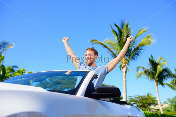 Road trip travel - free man driving car in freedom. Happy young adult cheering in convertible for his summer vacations