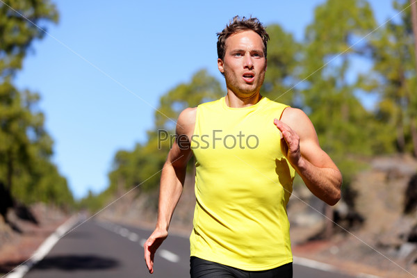 Running man sprinting for success on run. Male athlete runner training at fast speed. Muscular fit sport model sprinter exercising sprint on forest road. Caucasian fitness model in his 20s.