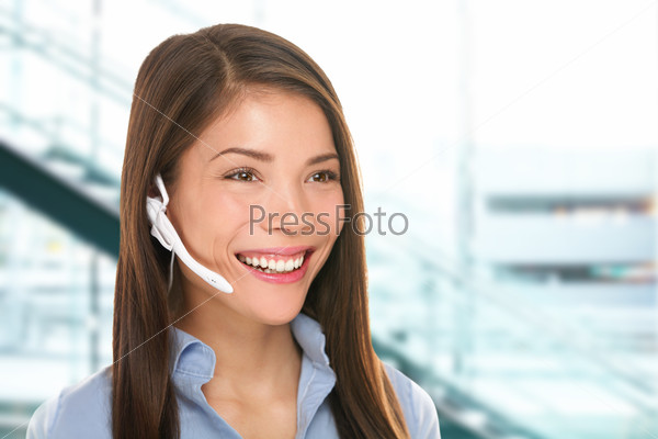 Headset customer service woman secretary at call center talking friendly smiling happy in office. Beautiful young mixed race Caucasian / Asian Chinese business woman working at hotline.