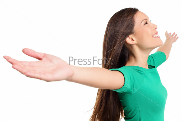 Free happy elated woman with arms out raised up in serene joyful pose. Girl in green shirt isolated on white background in studio. Mixed race Asian Caucasian female model.