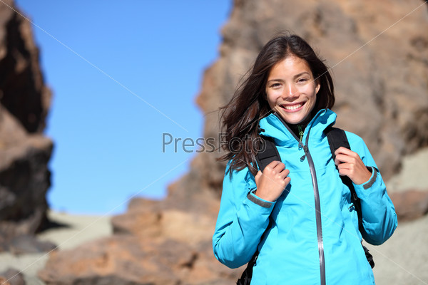 People hiking. Hiker woman looking at camera smiling happy portrait. Multicultural young woman walking in mountains with backpack