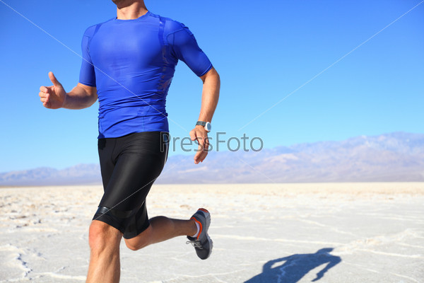 Sport - runner running and sprinting in desert. Athlete man during sprint run at great speed. Fitness man wearing compression clothes.