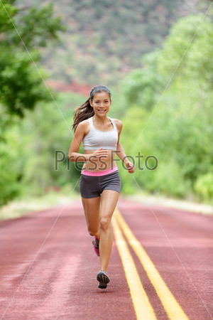 Runner woman running training living healthy fitness sport lifestyle. Active female athlete jogging outdoors happy with aspirations. Beautiful mixed race Asian Caucasian girl in full body length.