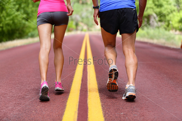 Running people. Runners jogging close up of sport fitness running shoes and legs and shorts. Athletes, woman and man in outdoor workout training for health and fitness.