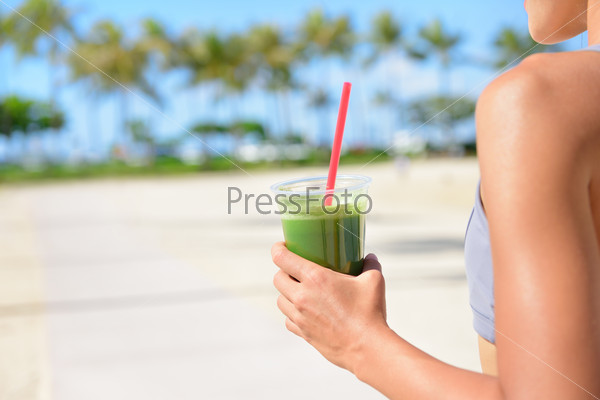 Vegetable green detox cleanse smoothie - Woman drinking after fitness running workout on summer day.