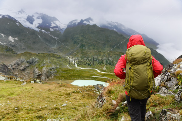 Hiking - hiker woman on trek with backpack living healthy active lifestyle. Hiker girl walking on hike in mountain nature landscape in Steingletscher, Urner Alps, Berne, Swiss alps, Switzerland.