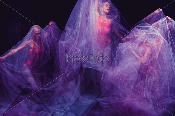Photo as art - a sensual and emotional dance of beautiful ballerina through the veil on a dark background. A stroboscopic image of the one model, stock photo
