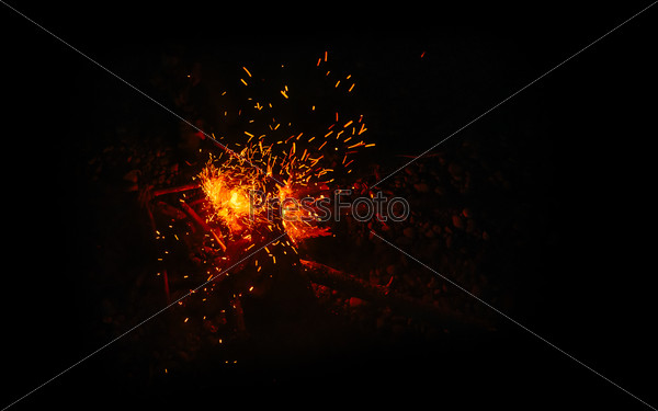 Magic fire on the river bank . Sparks, flames and other wonderful backgrounds for your text.