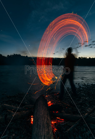 People - Bonfire on the river bank . Sparks, flames and other wonderful backgrounds for your text.