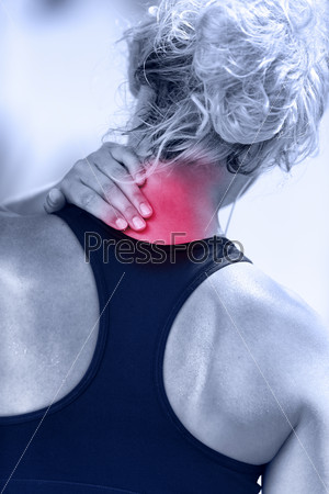 Hurting neck - female runner showing pain with red circle. Athletic running woman with injury in sportswear rubbing touching upper back muscles outside after exercising and training.