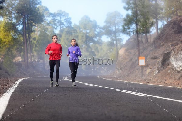 People running - athlete runners training jogging in cloudy and cold  weather. Exercising runner couple working out living healthy lifestyle  training for marathon together on mountain road. - Stock Image - Everypixel