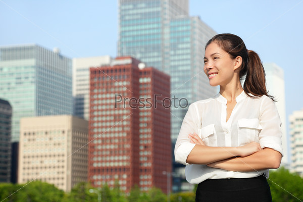 Asian businesswoman portrait in Tokyo. Happy confident young smart professional in casual business outfit in Japanese downtown Tokyo with skyline in the background.