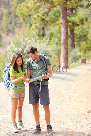 Hikers - hiking couple looking at map