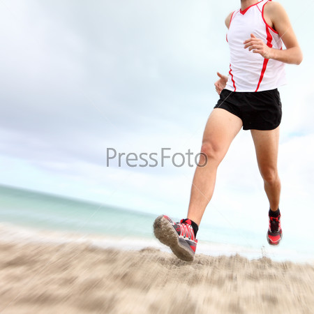 Running legs and shoes of runner jogging on beach. Caucasian sport man training for marathon.