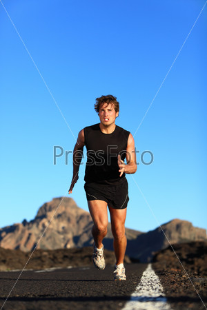 Running - male runner. Man sprinting during outdoor workout training session. Male caucasian athlete running on road in nature.