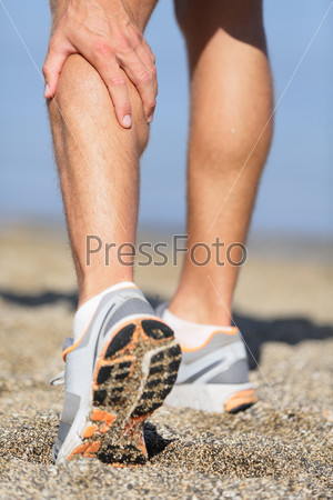 Sport injury - Man running clutching calf muscle