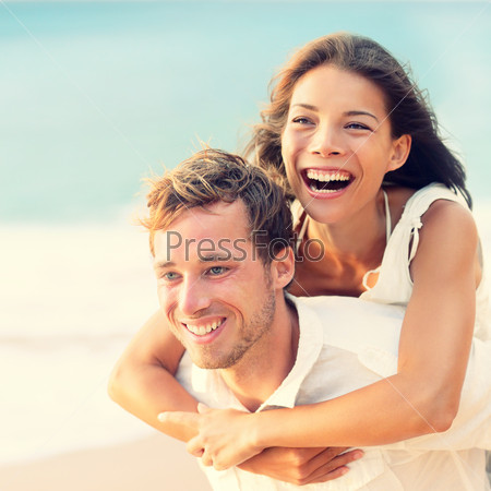 Love - Happy couple on beach having fun piggyback