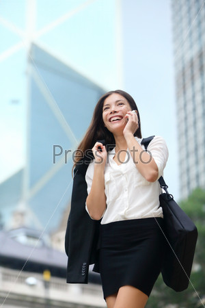 Business woman talking on phone outdoor, Hong Kong. Asian business people office worker talking on smartphone smiling happy. Young multiracial Chinese Asian / Caucasian female professional outside.