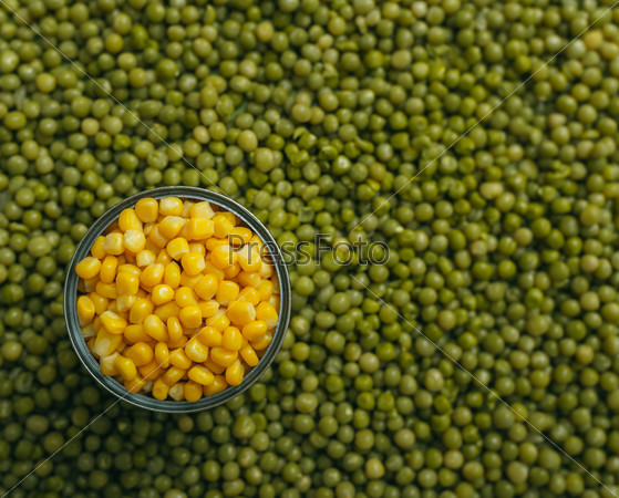 background of peas and corn laid by hand. remove debris . canned peas and corn . real.