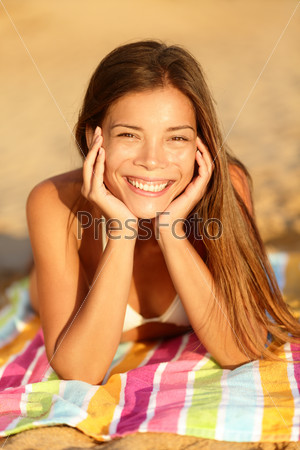 Summer woman sunbathing enjoying sun smiling looking at camera. Warm evening sunshine on pretty cute multiracial Asian Caucasian girl.