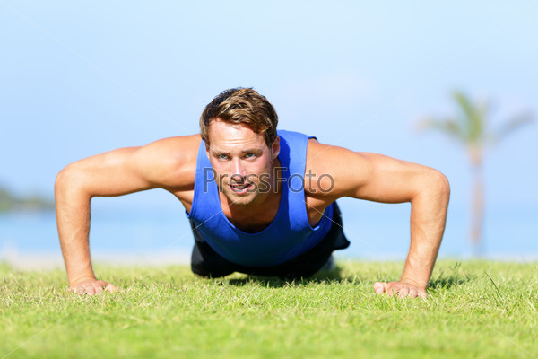 Push-ups - fitness man training push up outside in grass in\
summer. Fit male athlete working out cross training exercising\
outdoor. Caucasian muscular sports model in his 20s.