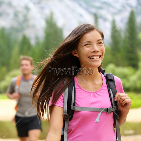 Hiker. Woman hiking smiling happy on trek with backpack during summer outdoors activity. Fresh joyful multiethnic Asian Caucasian female model walking in Yosemite National Park, California, USA