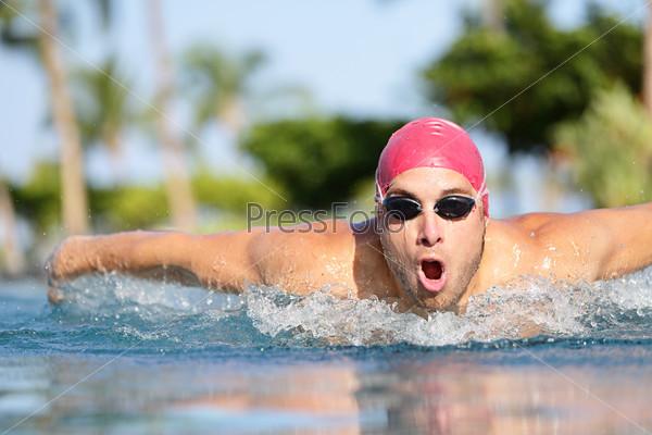 Swimmer man swimming butterfly strokes in pool