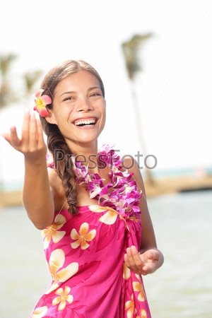 Hula dancer woman dancing hula dance on Hawaii wearing Hawaiian orchid flower lei smiling happy on beach. Travel vacation summer holidays image of beautiful mixed race girl in colorful pink sarong.