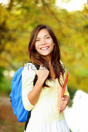 Asian student girl back to school university. Beautiful woman holding books in autumn background. Asian student girl on university college campus park smiling happy. Mixed race Asian Caucasian girl.